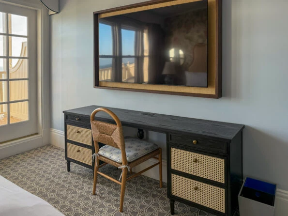 The desk and flat screen TV area near the balcony door.