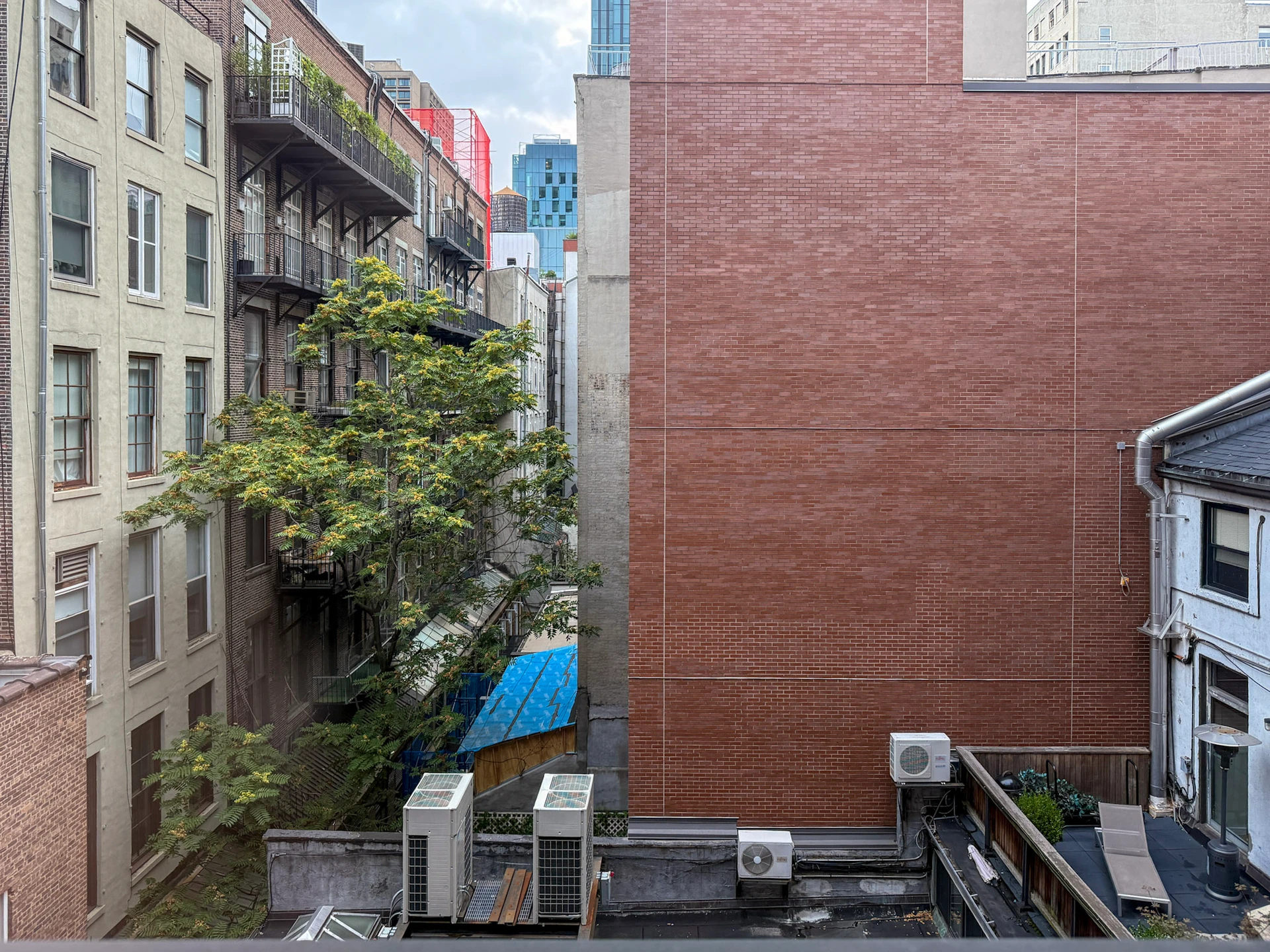 Loft studio courtyard view of rooftops and brick walls.