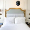 The lovely bed bed with gold headboard and crisp white sheets.