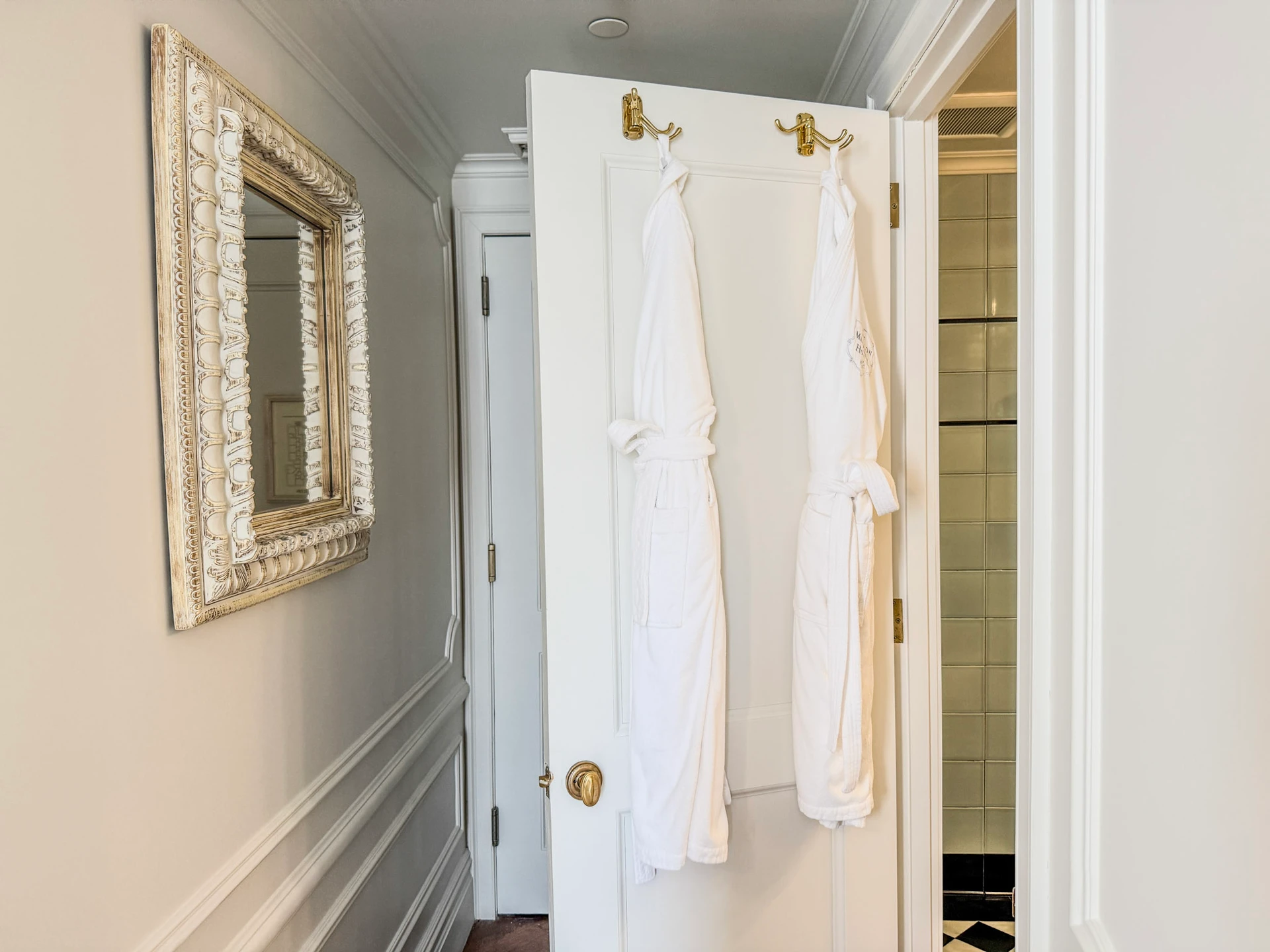 Two robes hang on the bathroom door in my room at The Marlton Hotel.