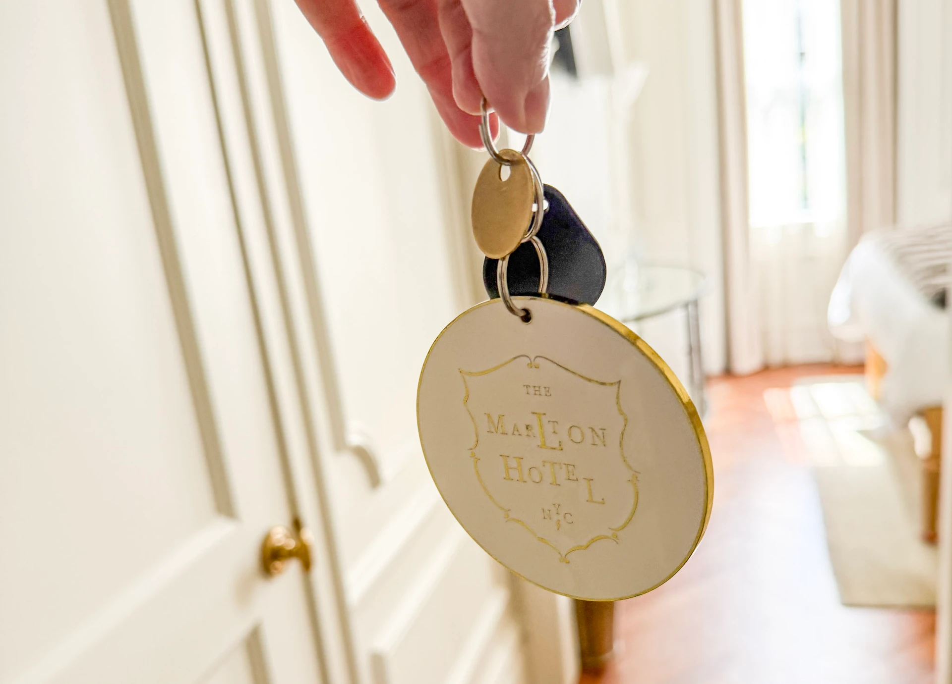 My room key fob and big circular metal key chain that says The Marlton Hotel NYC.