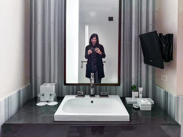 The marble bathroom with me in the mirror.