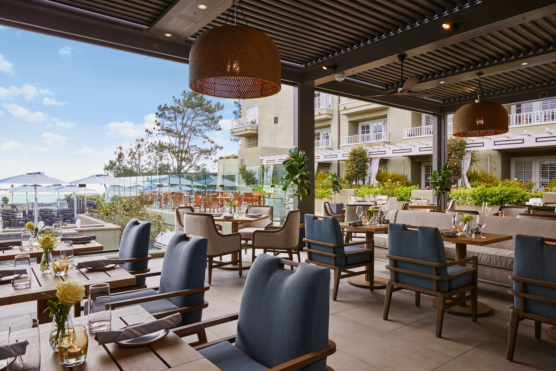 Adelaide restaurant patio dining area with view of hotel exterior and ocean view.
