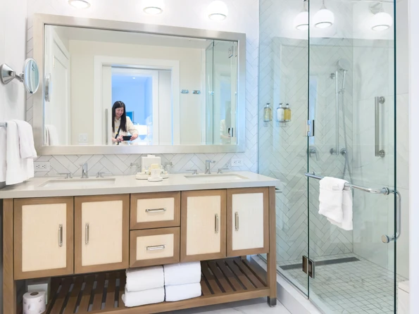 A white marble bathroom with shower in a Shore House room.