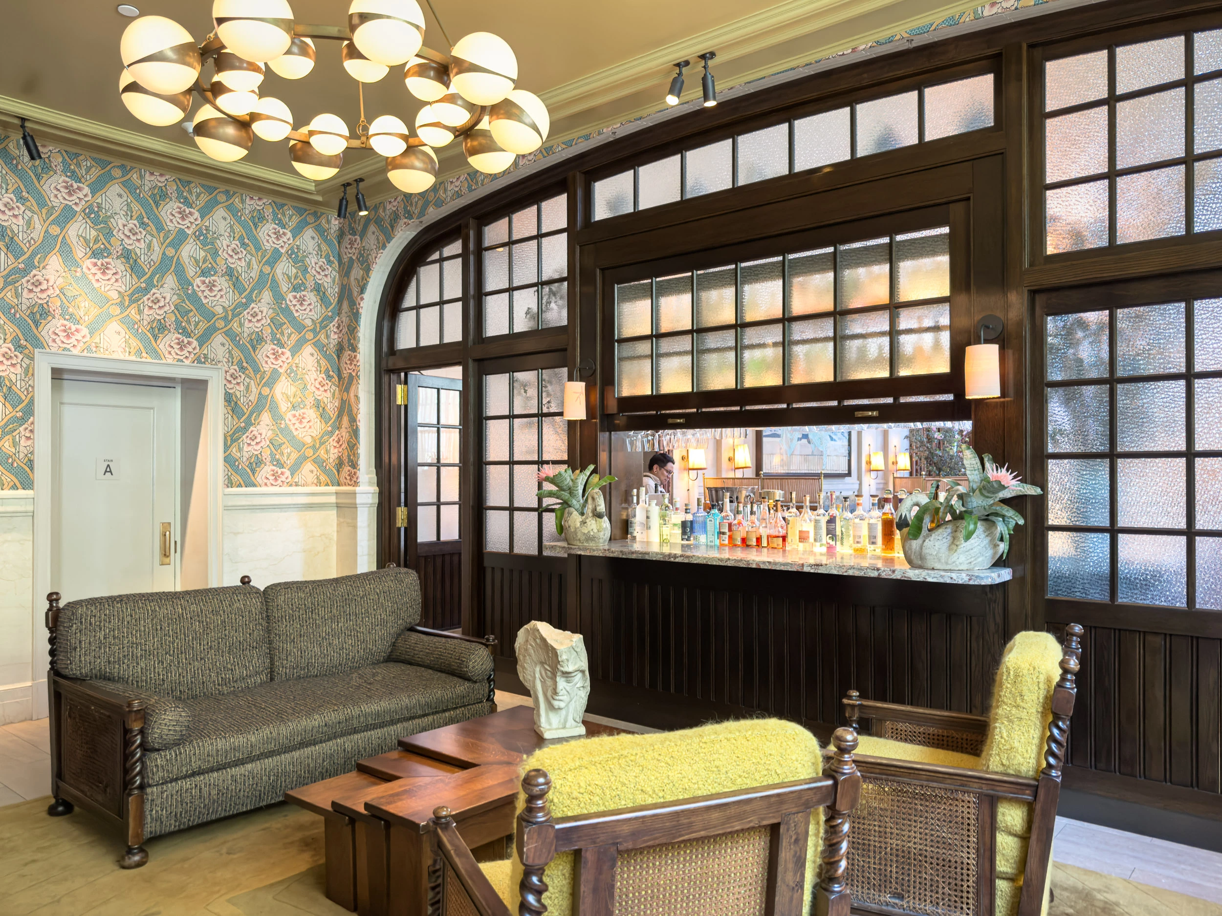 The lobby at Nine Orchard on the Lower East Side, with floral wallpaper and a bar