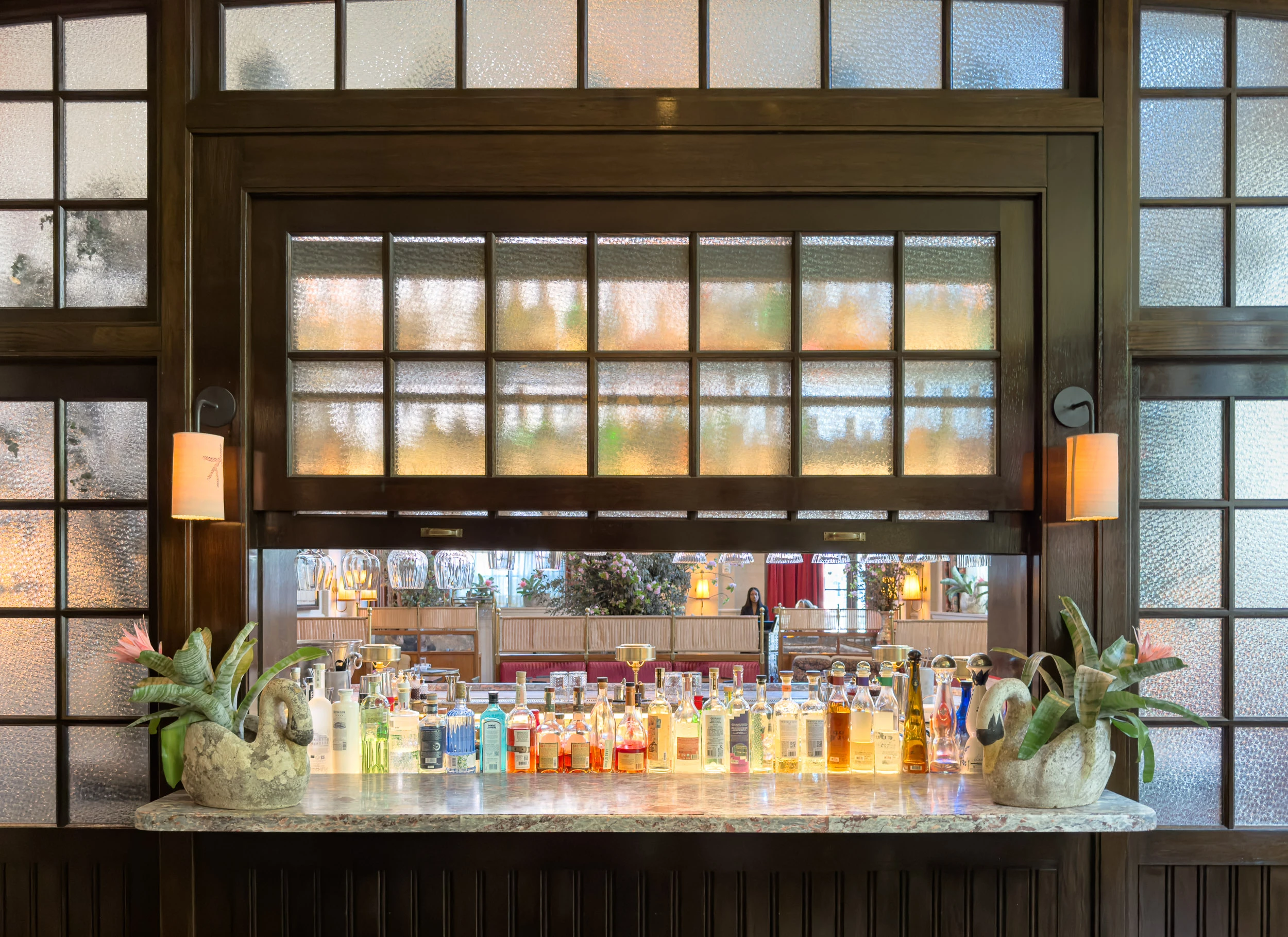 The Swan Room bar back at Nine Orchard with stone swan planters