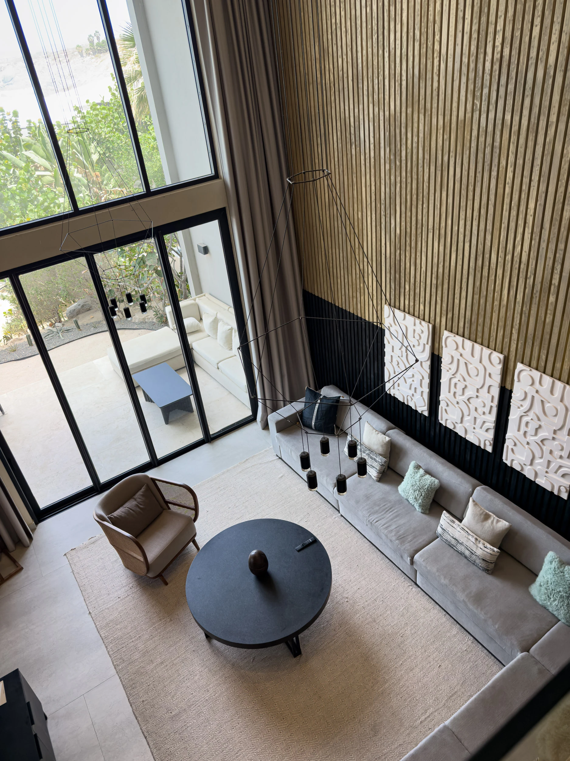 The double-height living area of a residence at The Cape, with floor-to-ceiling windows and a sectional sofa