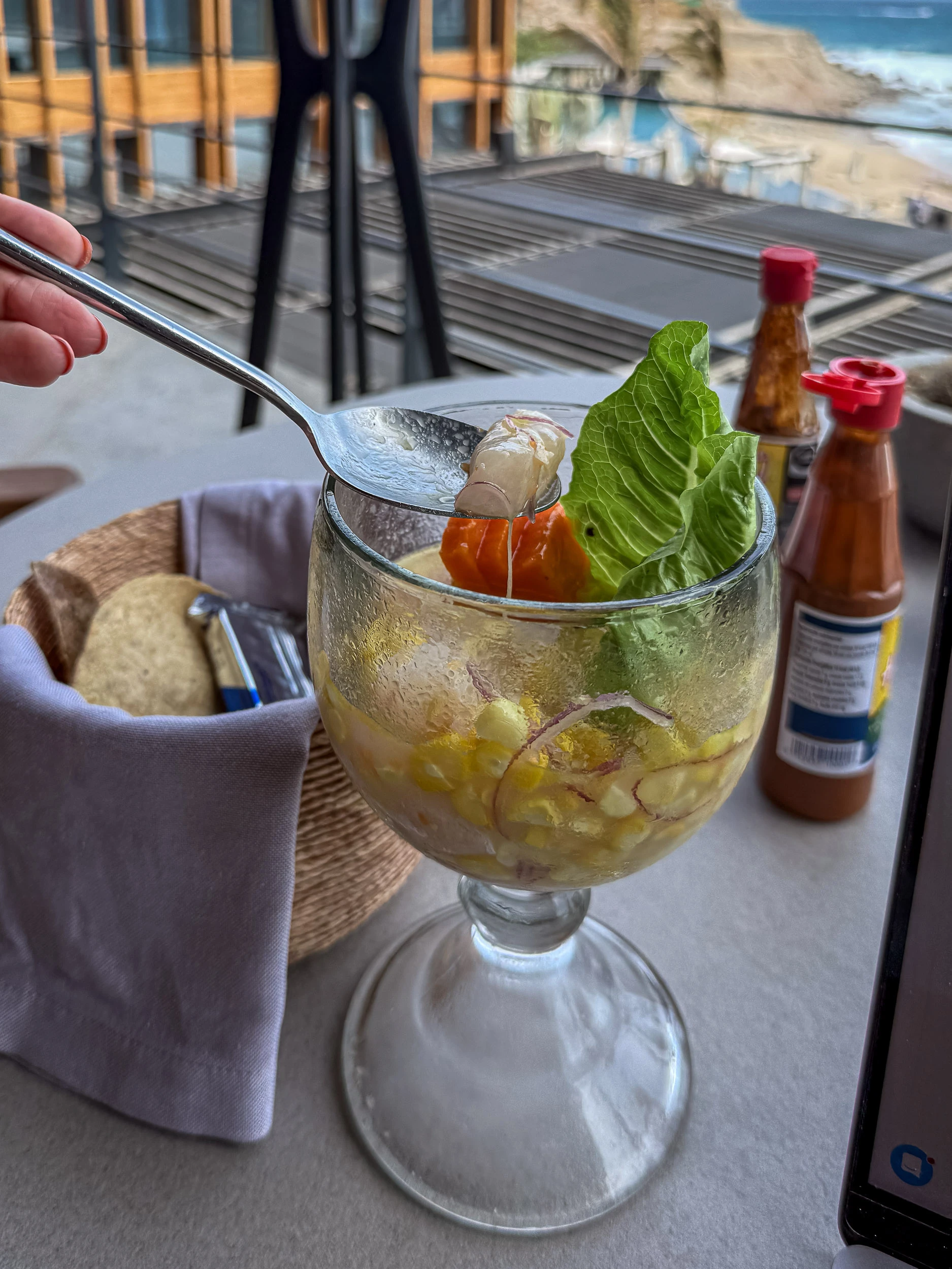 Seafood ceviche served in a glass with tortilla chips and hot sauces at The Cape, a Thompson Hotel