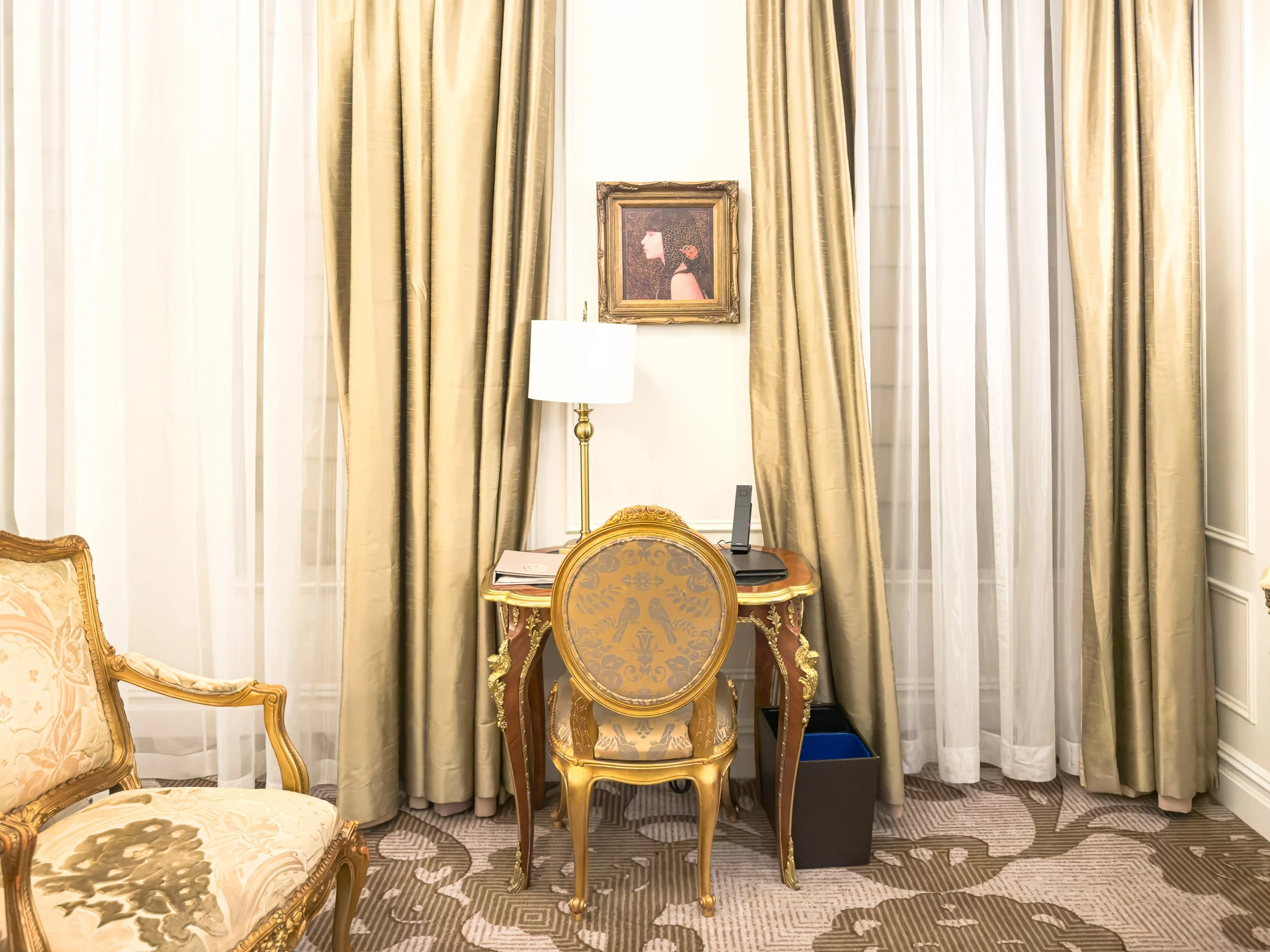 Sitting area with writing desk and silk curtains in a guest room at The Plaza Hotel New York