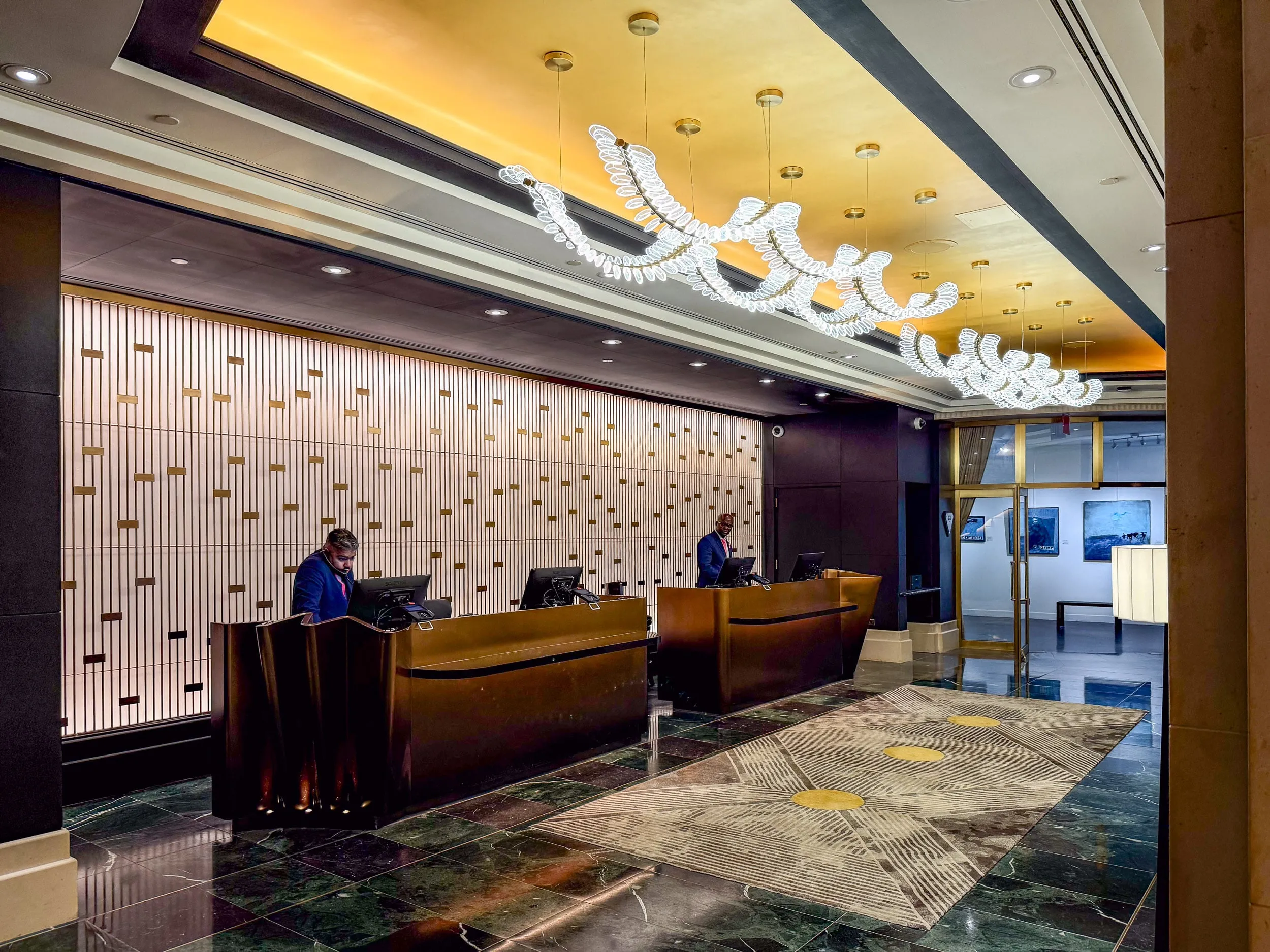 Two Sofitel New York City front desk staff work behind their computers at the check-in.