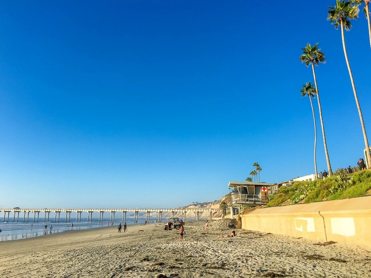 A view of La Jolla Shores Beach toward Scripps Pier on a sunny day.