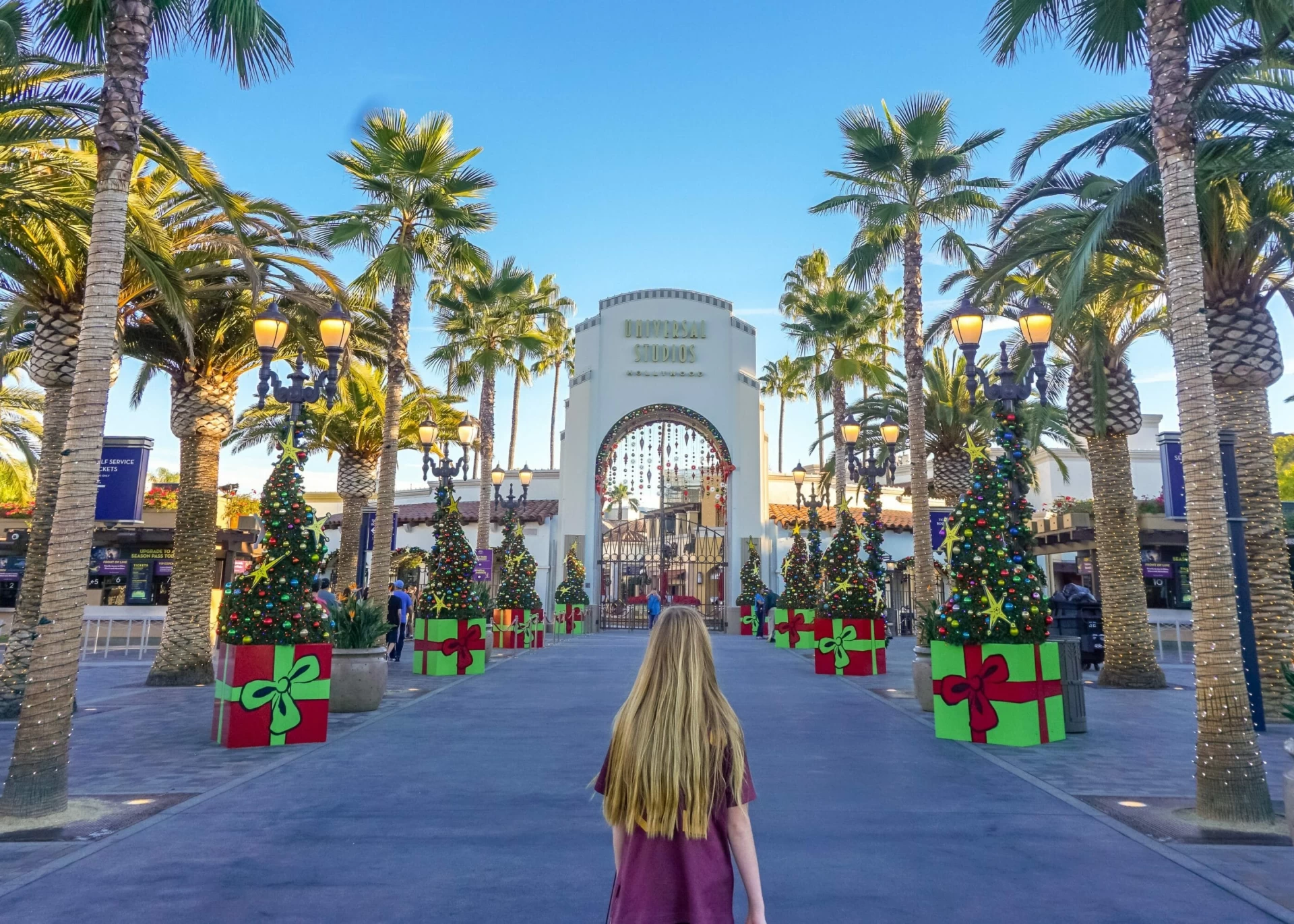 My daughter stands in front of the Universal Studios Hollywood entrance during the holiday season.