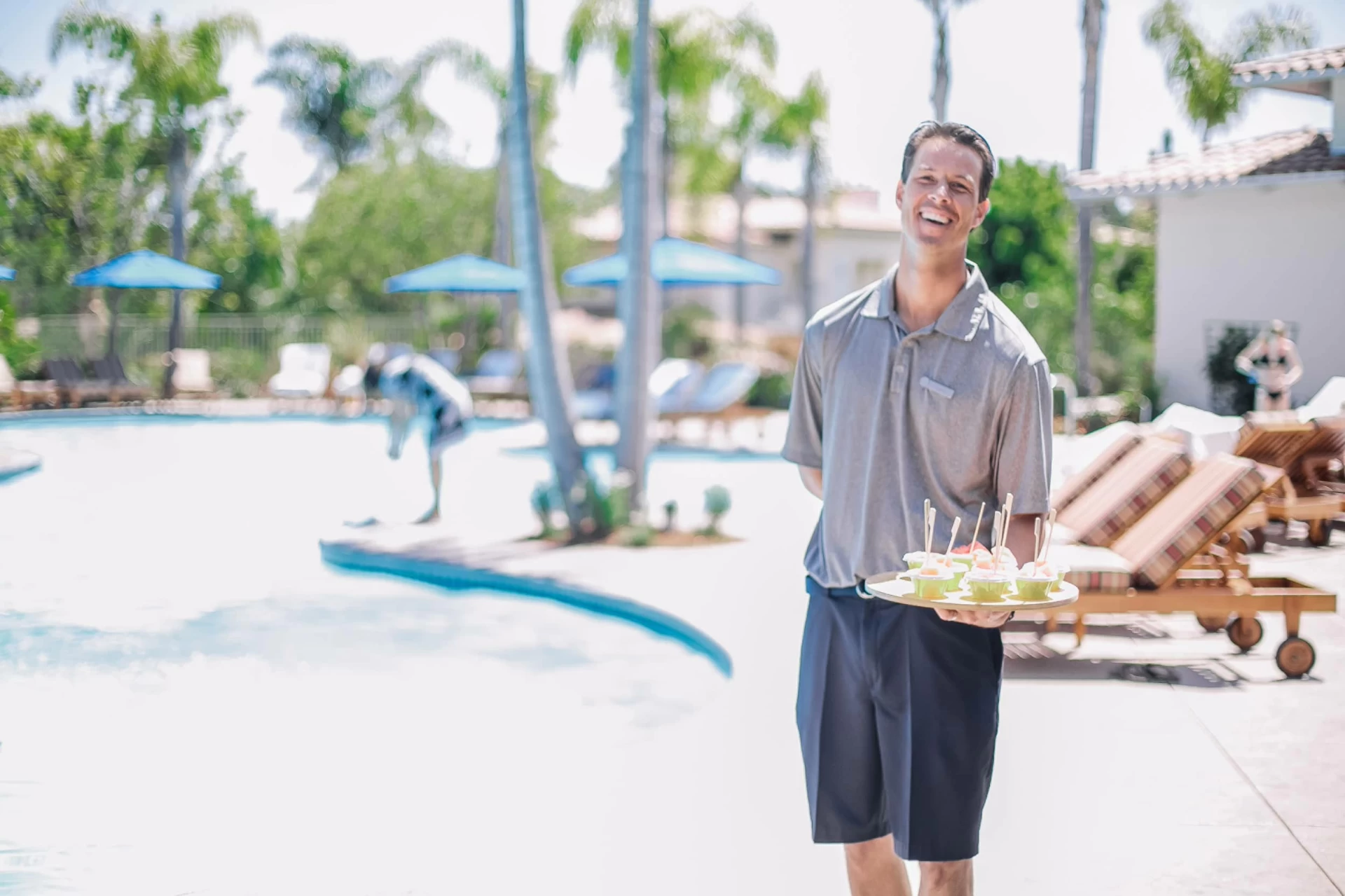 A staff member holds poolside treats at Four Seasons Residence Club San Diego, Aviara.