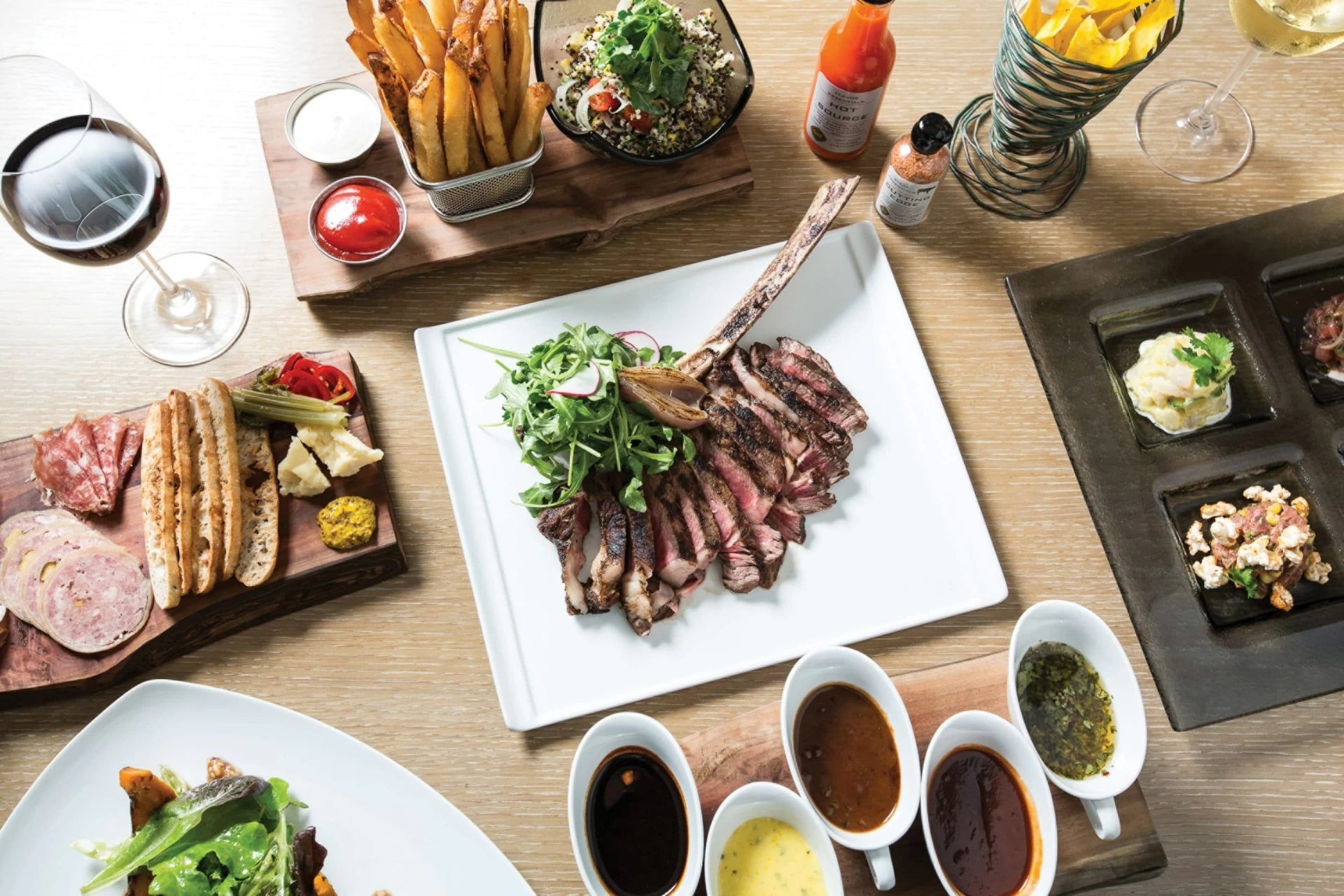 Plates of food including steak and sauces on a table at EDGE Steakhouse