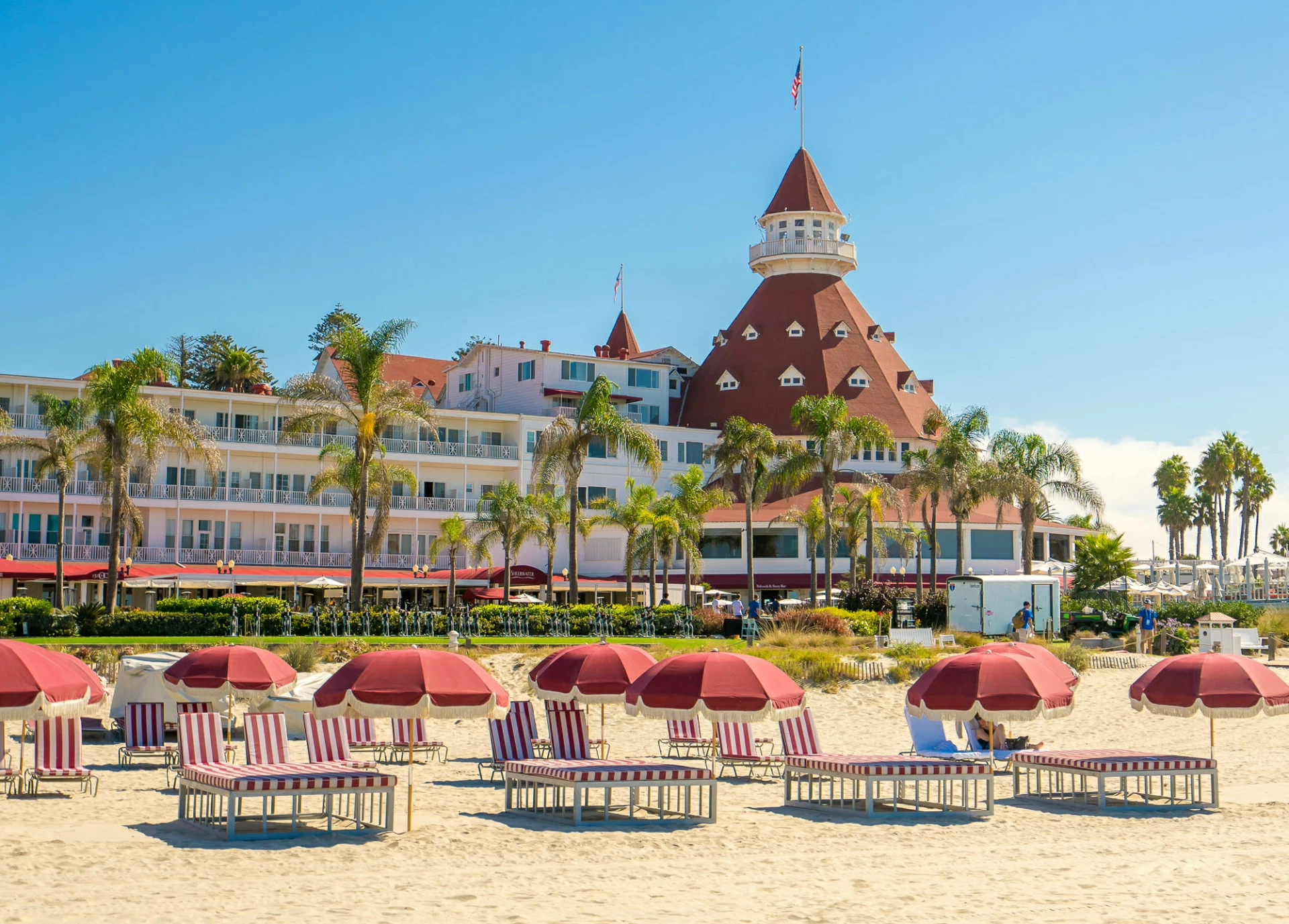 Red and white striped lounge chairs on the beach in front of Hotel del Coronado.