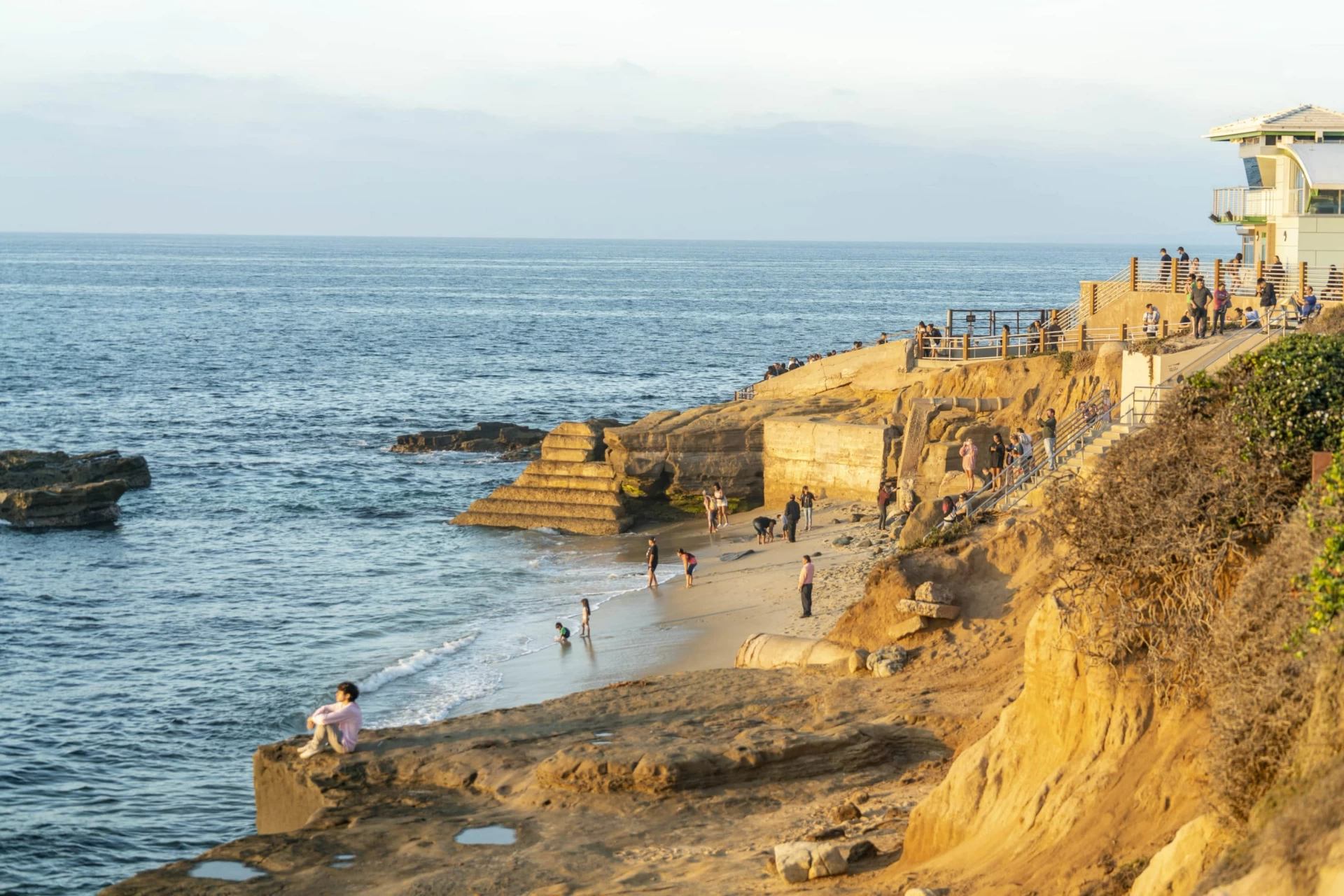 People enjoying South Casa Beach during golden hour on a sunny winter day in La Jolla, CA.