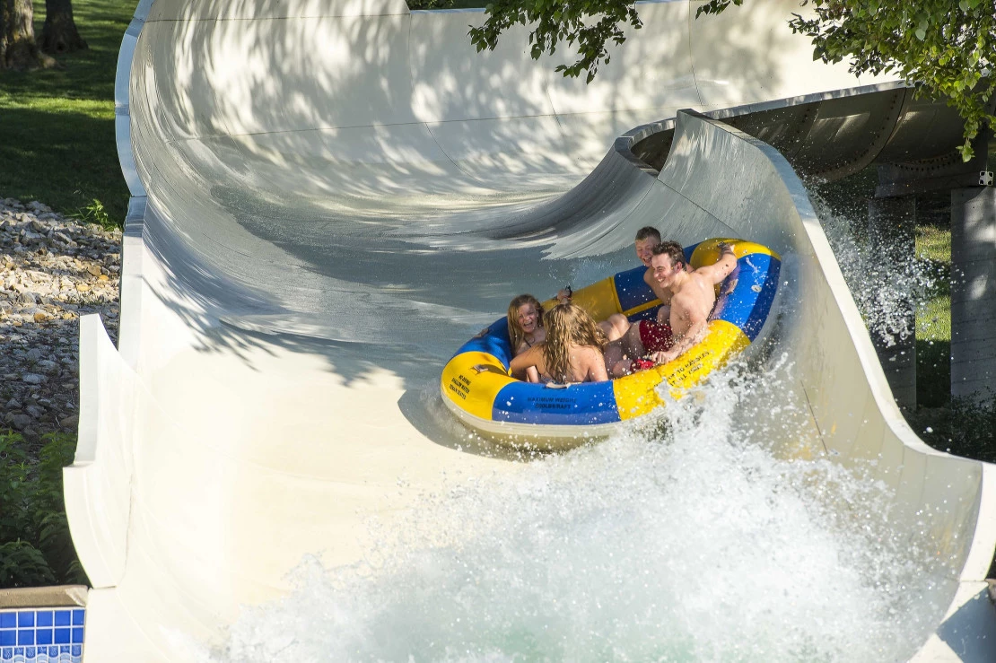 Guests in a raft ride down a water slide at Oceans of Fun.